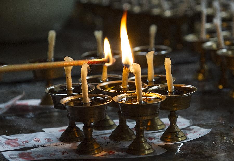 A citizen lights up a candle to mourn the sacrificed soldiers of China Expeditionary Army (CEA) in southwest China's Chongqing, Jan. 19, 2013. A commemorating ceremony was held on Saturday in the Luohan Temple to mourn a total of 202 CEA soldiers and officers who sacrificed in the battle of yenangyaung in Myanmar. An expeditionary force of 300,000 was sent to Myanmar to fight against the Japanese invaders during World War II. (Xinhua/Chen Cheng) 