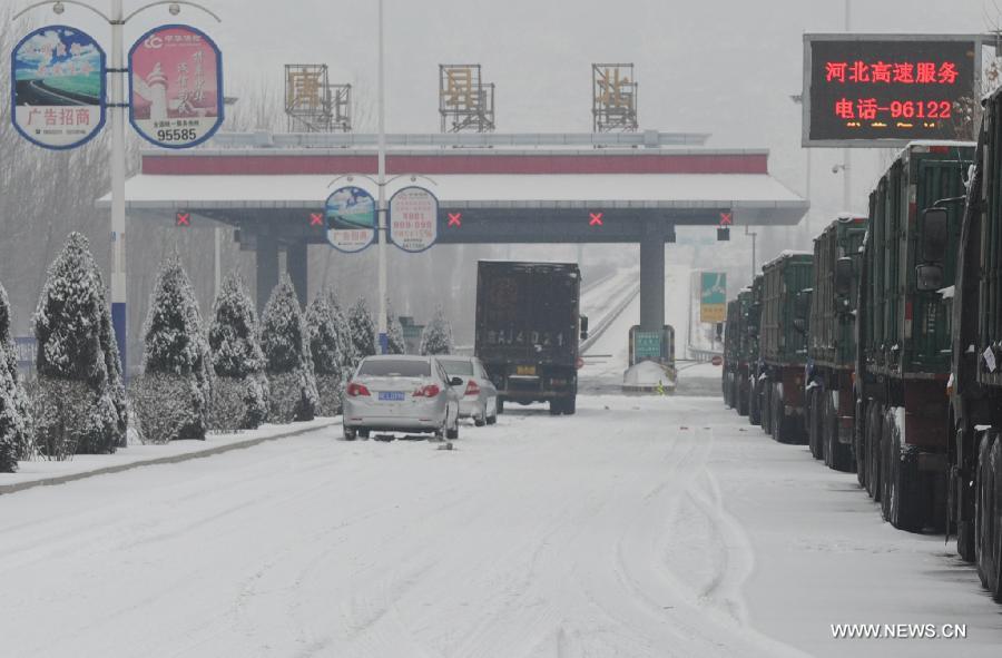 Vehicles queue outside the entrance of the Beijing-Kunming Expressway due to highway closure in Tangxian County, north China's Hebei Province, Jan. 20, 2013. Snow fell in most parts of Hebei Province on Jan. 19 evening and 19 expressways in the province have been closed. (Xinhua/Zhu Xudong) 