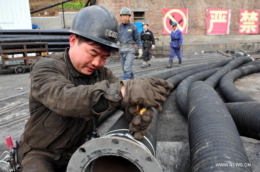A miner binds a ventilating duct before conveying rescue materials to the coalmine in which a coal and gas outburst has left two people dead at the Jinjia Coal Mine under the Panjiang Investment Holding Group in Liupanshui City, southwest China's Guizhou Province, Jan. 20, 2013. Rescuers have been working for 42 hours until 1 p.m. on Jan. 20, but they failed to find the trapped miners. (Xinhua/Yang Ying) 