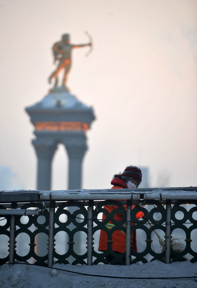 Yanng Weixia, a sanitation worker, cleans the street on Jan. 16, 2013. (Xinhua/Wang Jianwei)