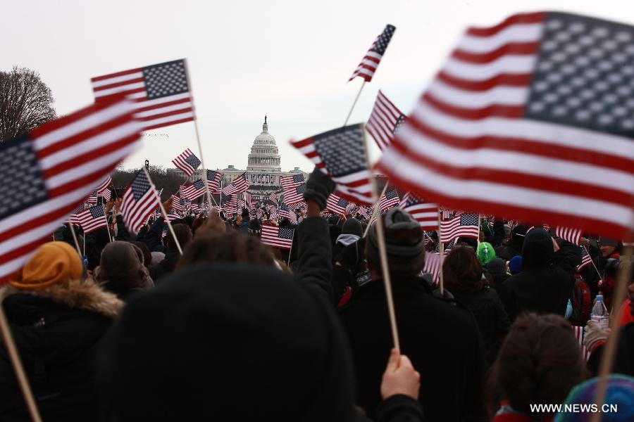 Spectators holding U.S. national flags watch the presidential inauguration ceremony on the West Front of the U.S. Capitol in Washington D.C., the United States, on Jan. 21, 2013. (Xinhua/Zhai Xi) 