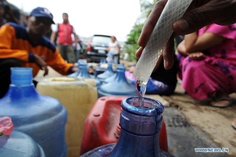 Refugees get water from the purification equipment provided by Indonesian Red Cross at Penjaringan in North Jakarta, Indonesia, Jan. 22, 2013. According to Indonesia's National Agency for Disaster Management (BNPB), around 20 people died from the recent massive flood that hit Jakarta. (Xinhua/Veri Sanovri)  