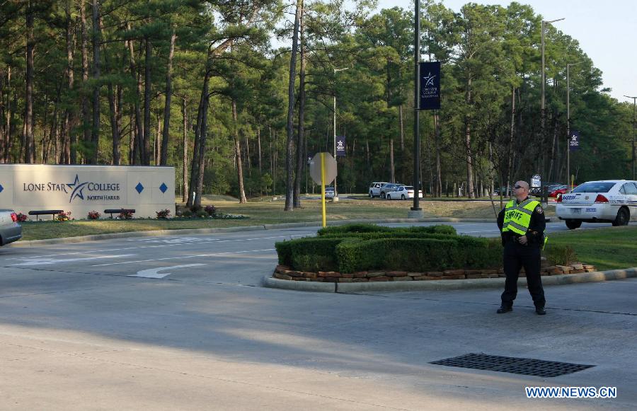 A policeman guards near the campus of Lone Star College in north Houston, the United States, Jan. 22, 2013. Three people, including a suspect, have been shot on the Lone Star College north campus in Houston on Tuesday, as a result of an argument between a student and a man, authorities said. (Xinhua/Song Qiong) 