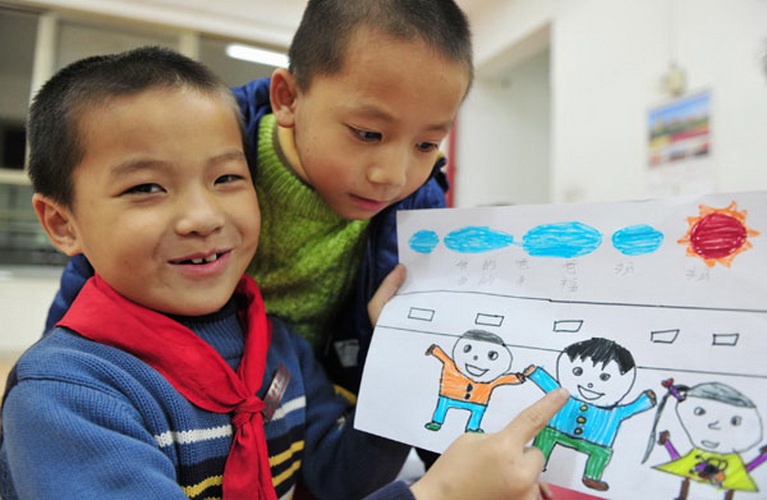 Jiang Tao shows his drawing in which he lives with his parents, but police have been unable to trace them and now he lives at an orphanage in Jinjiang, Fujian province, Jan 22. (Photo/Xinhua)