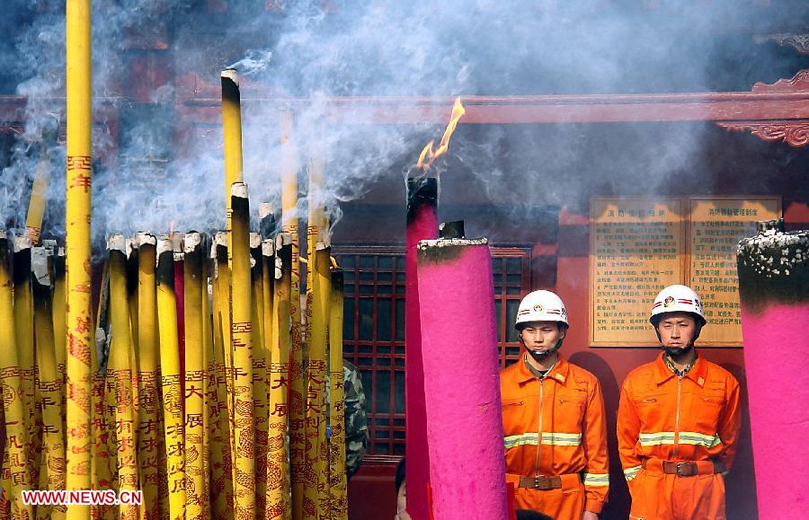 File photo taken on March 29, 2009 shows two firefighters stand by the incense area at a temple fair in Xinzheng City, central China's Henan Province. Temple fair in central China area is an important social activity for local people. The ancient temple fairs in central China were ceremonious sacrificial rituals. As time goes by, the focus of temple fair activities has shifted from "gods" to "people". The modern temple fair in central China is a platform of displaying folk culture as well as a channel for commodity circulation. According to statistics from the provincial cultural sector, there are about 35,000 temple fairs each year in Henan. (Xinhua/Wang Song)