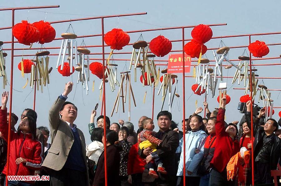 File photo taken on Feb. 9, 2005 shows people guess lantern riddles at a temple fair in Zhengzhou, capital of central China's Henan Province. Temple fair in central China area is an important social activity for local people. The ancient temple fairs in central China were ceremonious sacrificial rituals. As time goes by, the focus of temple fair activities has shifted from "gods" to "people". The modern temple fair in central China is a platform of displaying folk culture as well as a channel for commodity circulation. According to statistics from the provincial cultural sector, there are about 35,000 temple fairs each year in Henan. (Xinhua/Wang Song)