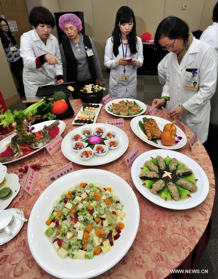 Dieticians from Taiwan University Hospital introduce the nutrition standards of creative dishes to media reporters in Taipei, southeast China's Taiwan, Jan. 23, 2013. Dieticians from Taiwan University Hospital created ten dishes mostly made from vegetables and fruits, promoting a healthy dinner in the coming Spring Festival. (Xinhua/Wu Ching-teng)