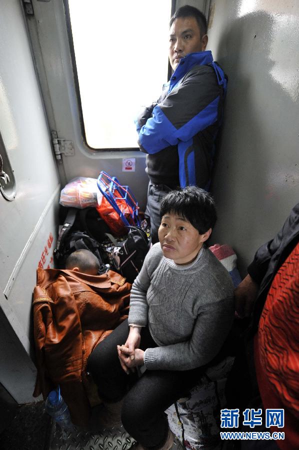 A family and their luggage occupy a junction of carriages, Jan. 17, 2013. (Photo/Xinhua)