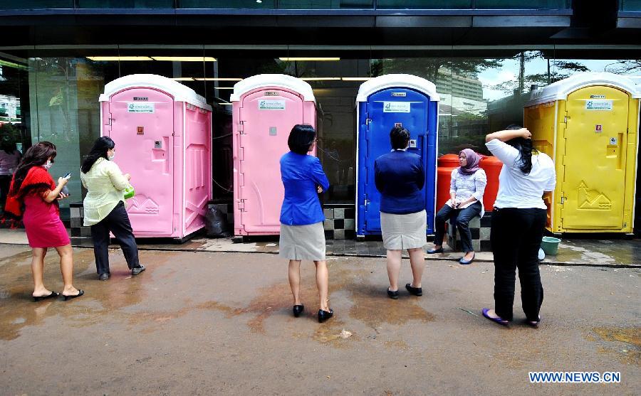 People queue in front of temporary toilets while the sanitation in the office building is failed by flood waters in Jakarta, Indoensia, Jan. 23, 2013. (Xinhua/Agung Kuncahya B.) 