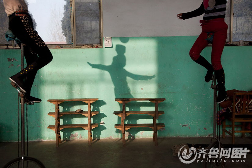 Two girls carry bowls on head standing on barrow. (Photo/ Yx.iqilu.com)