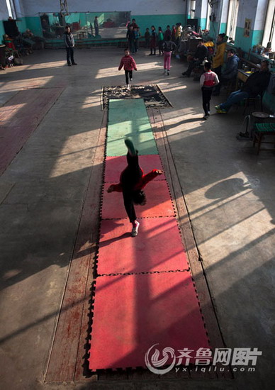 Children line up to turn somersault on mat. (Photo/ Yx.iqilu.com)