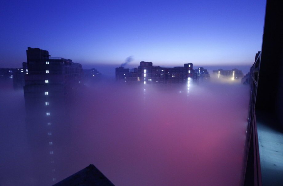 Dense fog hit back Beijing and caused serious air pollution on Tuesday and Wednesday. From the bird’s-eye view, the sleeping city was shrouded by fantasy created by shimmer of dawn, illumination and fog. (Photo/CCTV) 