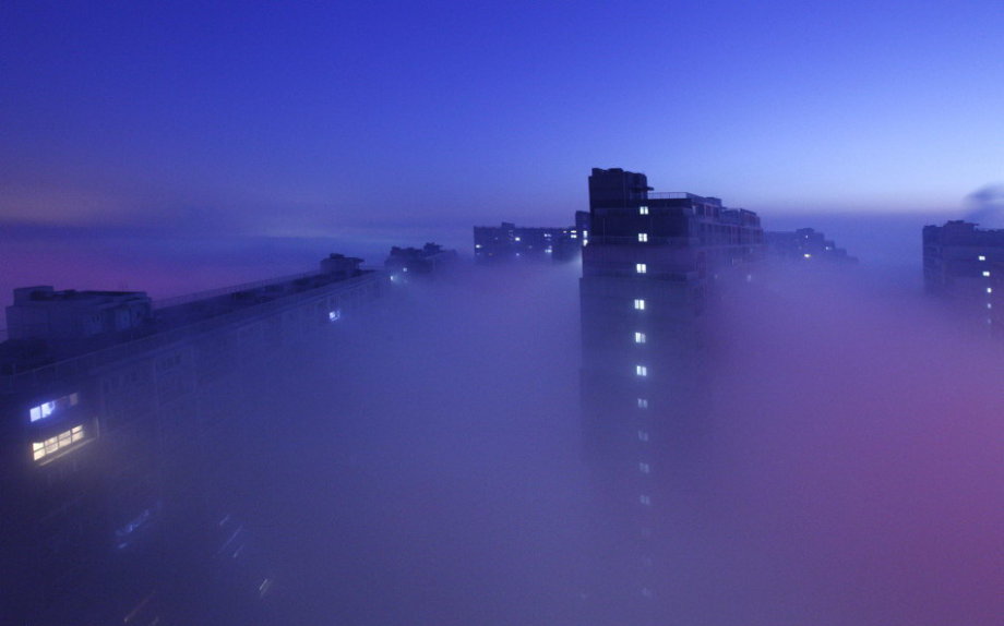 Dense fog hit back Beijing and caused serious air pollution on Tuesday and Wednesday. From the bird’s-eye view, the sleeping city was shrouded by fantasy created by shimmer of dawn, illumination and fog. (Photo/CCTV) 