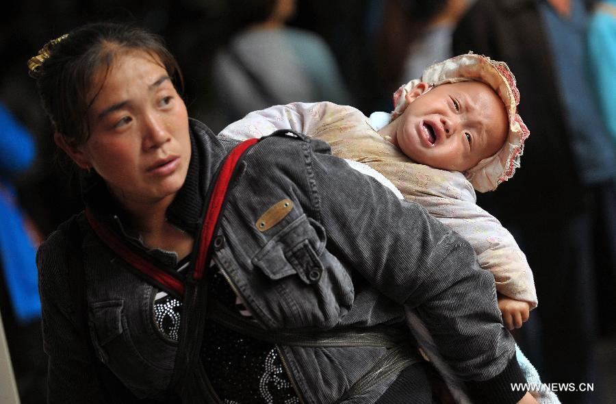 A woman carrying a baby prepares to board a ship at the Xiuying Port in Haikou, capital of south China's Hainan Province, Jan. 24, 2013. Haikou witnessed a travel rush on Thursday as the Spring Festival draws near. (Xinhua/Guo Cheng)