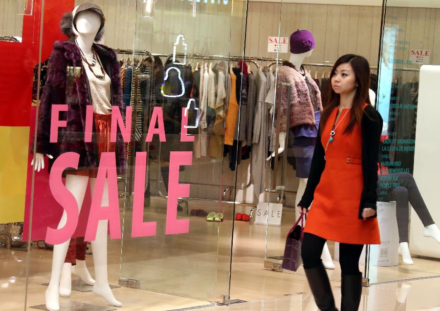 A woman walks past a shop in the Elements of Kowloon in Hong Kong, south China, Jan. 24, 2013. As the Spring Festival coming, shops in Hong Kong started to offer discounts for increasing customers. (Xinhua/Li Peng)