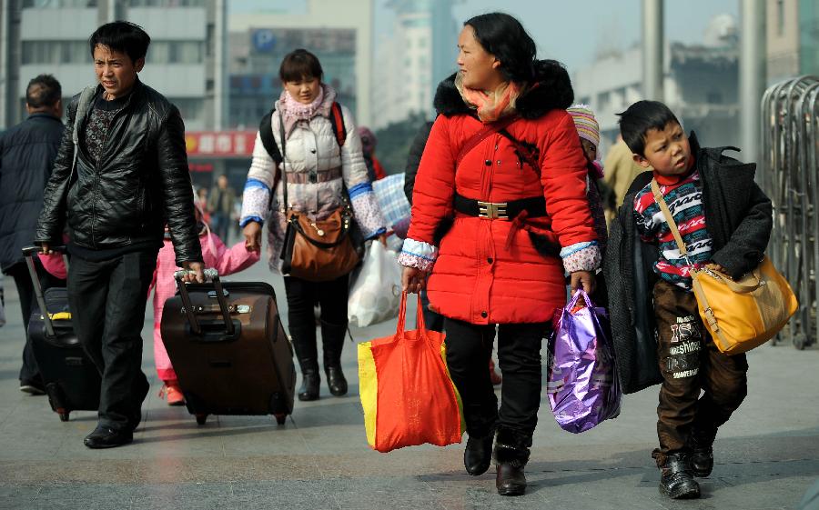 Passengers carry their luggage on the square of the train station in Chengdu, capital of southwest China's Sichuan Province, Jan. 24, 2013. As the spring festival approaches, more than more people started their journey home. (Xinhua/Xue Yubin) 