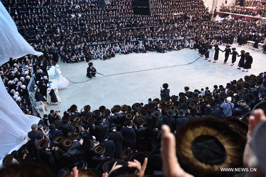 Grand Rabbi of the Satmar hassidic dynasty Rabbi Zalman Leib Teitelbaum (in white dress) dances with his relatives and the groom Moshey Chaim during his first granddaughter's wedding in Israeli town of Beit Shemesh, on Jan. 24, 2013. The wedding was held here from the evening of Jan. 23 to the morning of Jan. 24. Some 5,000 guests attended the traditional Jewish wedding. (Xinhua/Yin Dongxun)