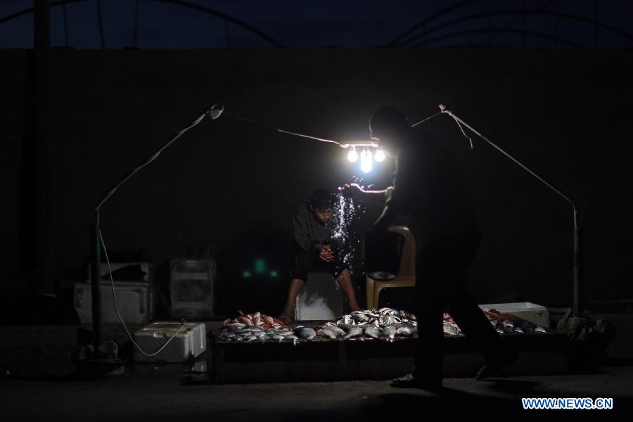 Palestinian fishermen sell fish on a beach upon their return from the sea, in Gaza City on Jan. 23, 2013. (Xinhua/Wissam Nassar)