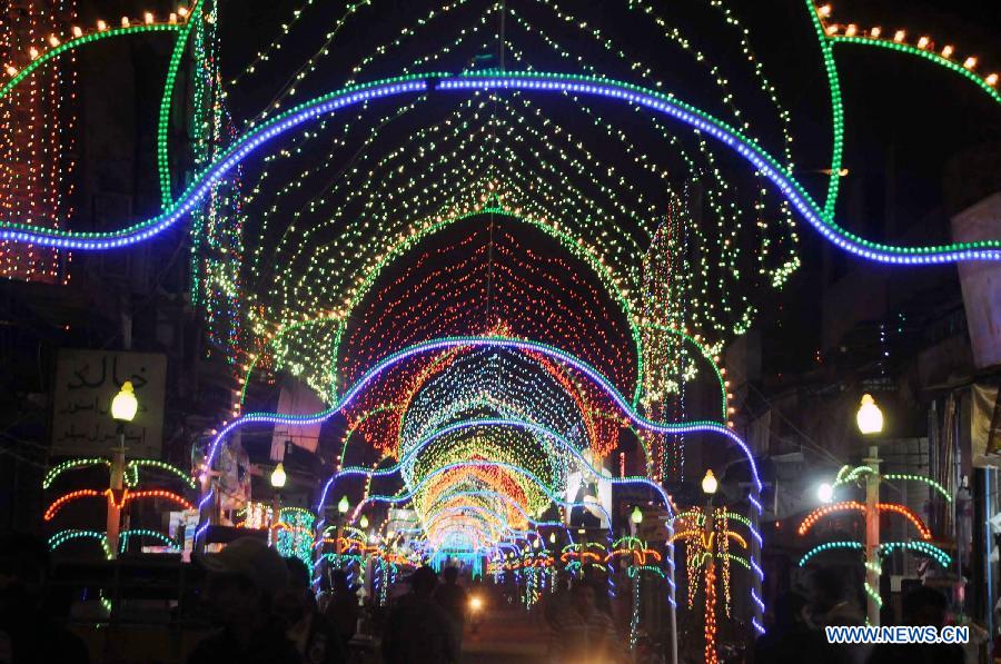 Pakistani pedestrians walk on an illuminated street during celebrations ahead of Eid-e-Milad-un-Nabi, marking the birth of the Prophet Mohammed, the founder of Islam, in southern Pakistani port city of Karachi on Jan. 24, 2013. Pakistani Muslims will celebrate the birth of the Prophet Mohammed on Jan. 25. (Xinhua/Masroor)