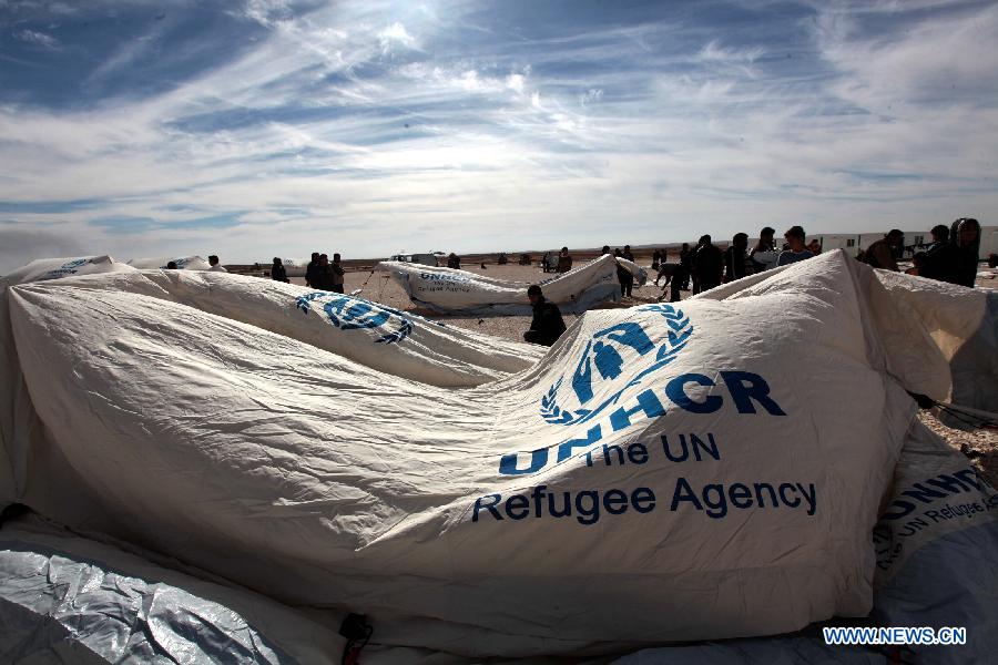 Relief workers erect a tent in Zaatari refugee camp, near the desert town of Mafraq, northeast of Amman, Jan. 24, 2013. The past six days witnessed a record surge in the number of Syrian refugees seeking safety in Jordan. The number of refugees has pushed up the Syrian population in Jordan to around 300,000. (Xinhua/Mohammad Abu Ghosh) 