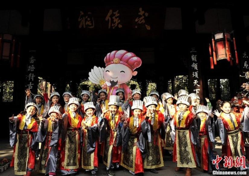 Children in costumes of "God of Happiness" meet the media in the Wuhou Memorial Temple in Chengdu, Sichuan Province, January 24, 2013. They will perform at a temple fair during the Spring Festival.  (Photo: CNS/An Yuan)