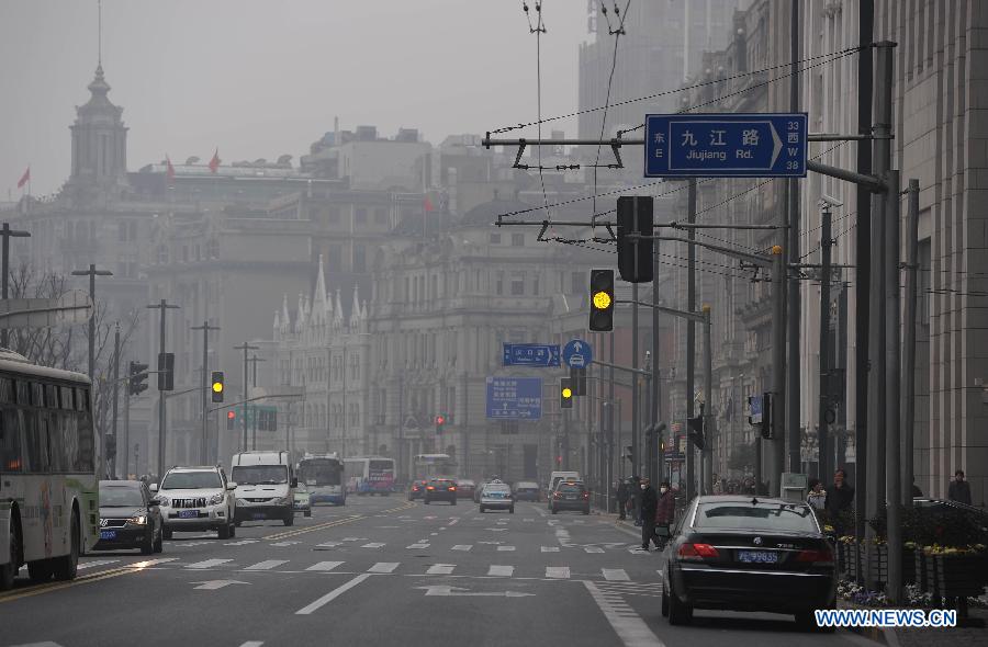 Vehicles run on a road along the Bund in the fog in east China's Shanghai Municipality, Jan. 24, 2013. Fog hit Shanghai Thursday. (Xinhua/Lai Xinlin) 