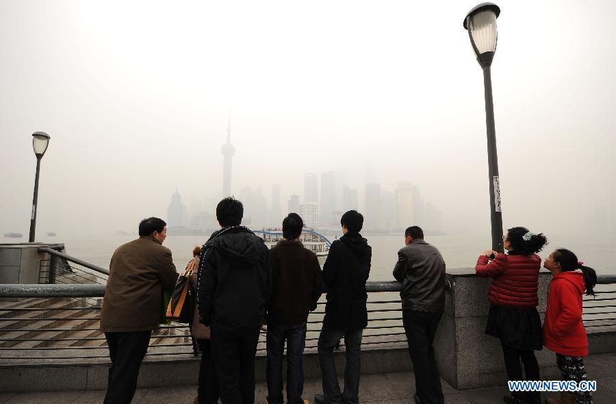 Tourists visit the Bund in the fog in east China's Shanghai Municipality, Jan. 24, 2013. Fog hit Shanghai Thursday. (Xinhua/Lai Xinlin)