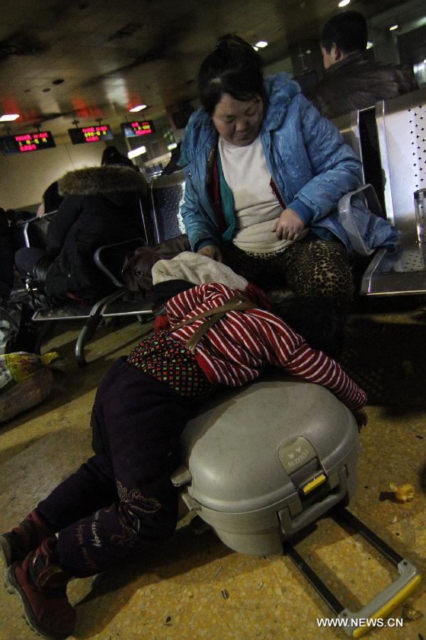 A child rests on the luggage while waiting for a train at the Changzhou Railway Station in Changzhou City, east China's Jiangsu Province, Jan. 26, 2013. The 40-day Spring Festival travel rush started on Saturday. The Spring Festival, which falls on Feb. 10 this year, is traditionally the most important holiday of the Chinese people. It is a custom for families to reunite in the holiday, a factor that has led to massive seasonal travel rushes in recent years as more Chinese leave their hometowns to seek work elsewhere. Public transportation is expected to accommodate about 3.41 billion travelers nationwide during the holiday, including 225 million railway passengers, (Xinhua/Chen Wei) 