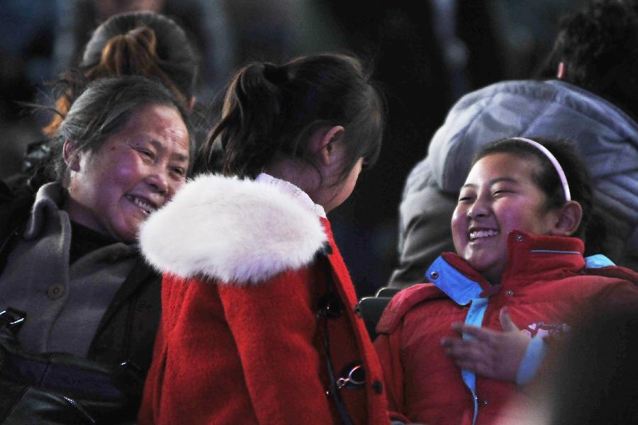 Two girls wait for their train home with their family members at Tianjin train station in north China's Tianjin Municipality, Jan. 25, 2013. The 40-day Spring Festival travel will begin on Jan. 26. The Spring Festival, the most important occasion for a family reunion for the Chinese people, falls on the first day of the first month of the traditional Chinese lunar calendar, or Feb. 10 this year. The number of passengers would reach 3.407 billion person-time during the 2013 Spring Festival travel, an 8.6 percent increase year on year. (Xinhua/Yang Baosen)