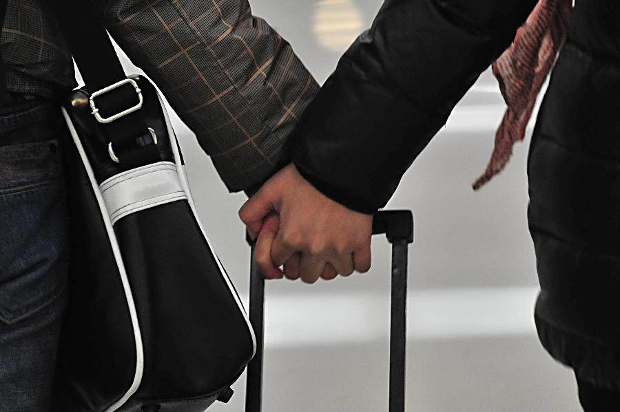 A couple waits hand in hand to take their train at Tianjin train station in north China's Tianjin Municipality, Jan. 25, 2013. The 40-day Spring Festival travel will begin on Jan. 26. The Spring Festival, the most important occasion for a family reunion for the Chinese people, falls on the first day of the first month of the traditional Chinese lunar calendar, or Feb. 10 this year. The number of passengers would reach 3.407 billion person-time during the 2013 Spring Festival travel, an 8.6 percent increase year on year. (Xinhua/Liu Zerui)