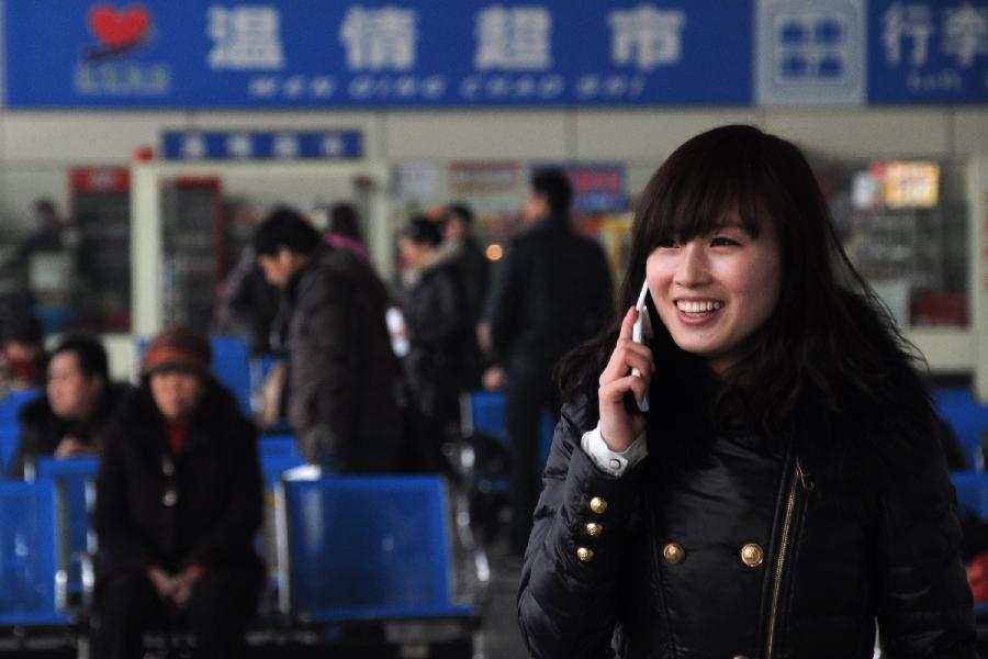 A woman calls her family member to inform on her homecoming at the bus terminal in Binzhou, east China's Shandong Province, Jan. 25, 2013. The 40-day Spring Festival travel will begin on Jan. 26. The Spring Festival, the most important occasion for a family reunion for the Chinese people, falls on the first day of the first month of the traditional Chinese lunar calendar, or Feb. 10 this year. The number of passengers would reach 3.407 billion person-time during the 2013 Spring Festival travel, an 8.6 percent increase year on year. (Xinhua/Yang Baosen)