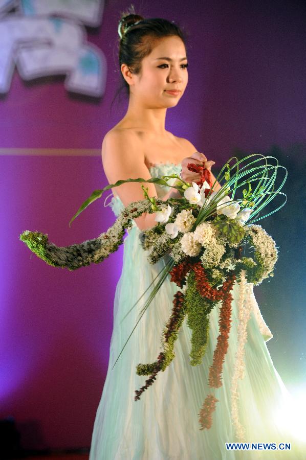 A model presents floral designs during the Flower Fair in Nanjing, capital of east China's Jiangsu Province, Jan. 25, 2013. (Xinhua/Sun Can)