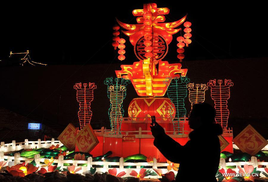 A visitor takes photos of colored lanterns on display at an ice and lantern art festival in Hengcheng scenic spot of Yinchuan, capital of northwest China's Ningxia Hui Autonomous Region, Jan. 25, 2013. The festival kicked off here on Friday. (Xinhua/Peng Zhaozhi) 