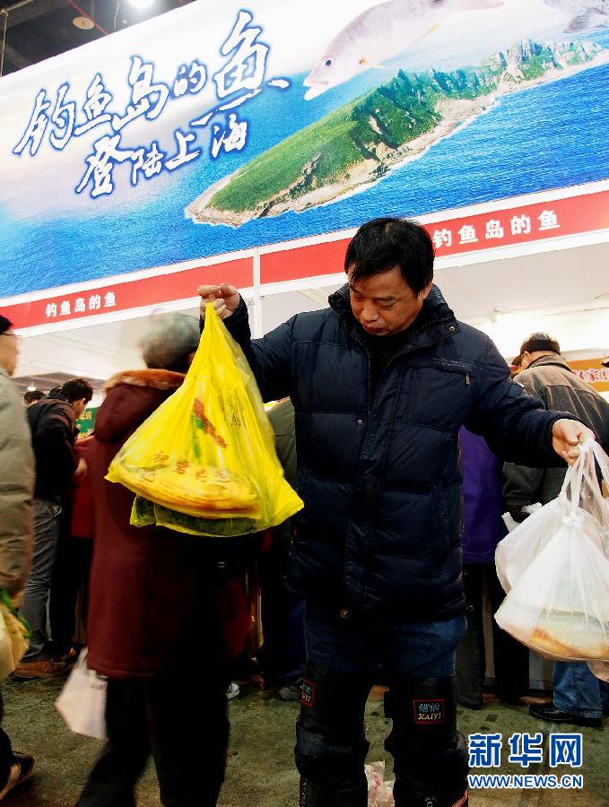 Shanghai consumers select deep-sea fishes caught in waters off the Diaoyu Islands, Jan. 26. On Saturday, fine and fresh fishes  of 4,000 kilograms were sold out in Shanghai market. The fishermen said the country’s maritime law enforcement activities off the islands boost their sense of safety and the yields of fishes. (Xinhua/Chen Fei)