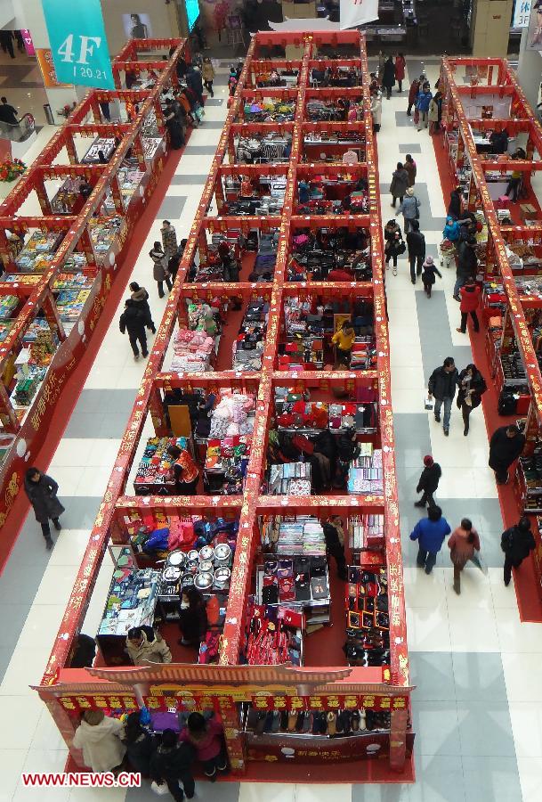 Customers select goods for the upcoming Spring Festival, at a shopping mall in Beijing, capital of China, Jan. 27, 2013. Retailers all around the country take many kinds of sales boosting measures to attract shoppers as Chinese Spring Festival approaches. (Xinhua/Li Xin)