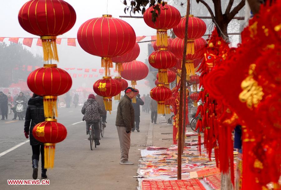 People go shopping at a market in Shijiazhuang, capital of north China's Hebei Province, Jan. 27, 2013. The market offers local customers goods and supplies for the coming Spring Festival which falls on Feb. 10 this year.(Xinhua/Zhu Xudong)