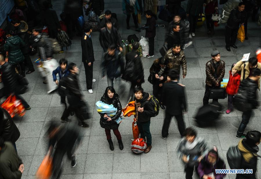 A couple look at train information at Hangzhou train station in Hangzhou, capital of east China's Zhejiang Province, Jan. 27, 2013. The 40-day Spring Festival travel rush began on Saturday. The Spring Festival, the most important occasion for a family reunion for the Chinese people, falls on the first day of the first month of the traditional Chinese lunar calendar, or Feb. 10 this year. (Xinhua/Han Chuanhao)