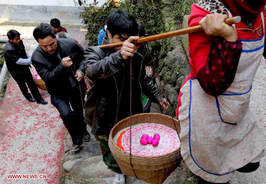 People head for a wedding dinner with presents at Chanru Village of Wangdong Town in Rongshui County, south China's Guangxi Zhuang Autonomous Region, Jan. 27, 2013. (Xinhua/Long Tao)