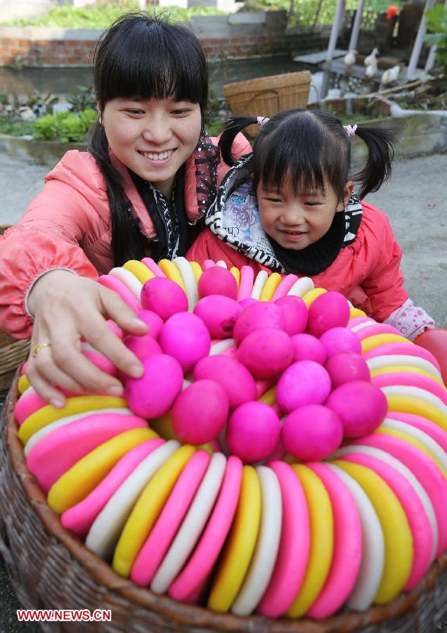 A woman of Zhuang ethnic group prepares a kind of local food made of glutinous rice as gift for a wedding at Chanru Village of Wangdong Town in Rongshui County, south China's Guangxi Zhuang Autonomous Region, Jan. 27, 2013. (Xinhua/Long Tao)