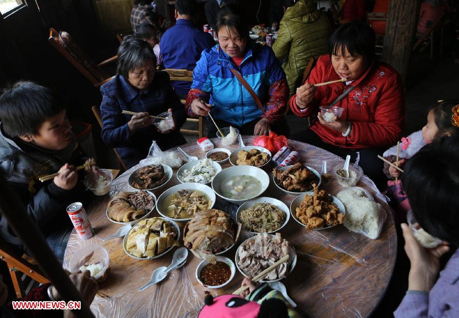 People have wedding dinner at Chanru Village of Wangdong Town in Rongshui County, south China's Guangxi Zhuang Autonomous Region, Jan. 27, 2013. (Xinhua/Long Tao)