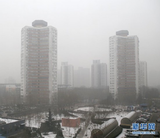 A photo taken on Jan. 23 shows residential buildings in Beijing standing in the heavy fog. Beijing's meteorological center on Monday issued a yellow-coded alert for haze as the fourth foggy weather in this month hit the city and cuts the visibility below 3,000 meters in major parts of Beijing. (Photo/Xinhua)