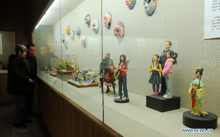 Visitors look at figures made of clay during an exhibition of traditional culture in Shijiazhuang, capital of north China's Hebei Province, Jan. 28, 2013. An 8-day exhibition in celebration of the coming Spring Festival was held in Shijiazhuang on Monday. (Xinhua/Zhu Xudong)