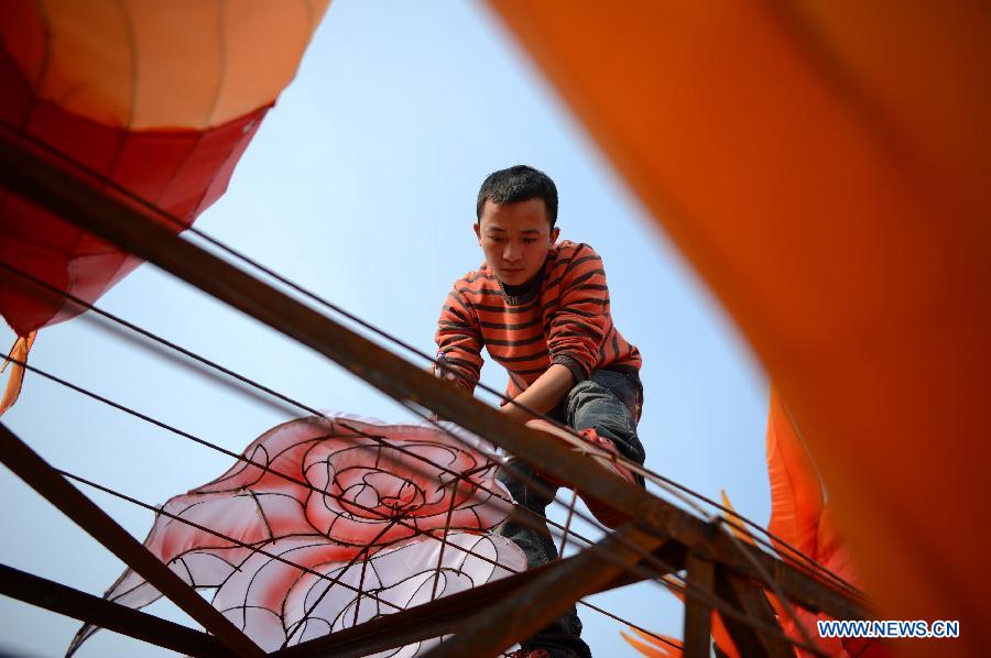 A man works on a lantern in the shape of Chinese dragon on the street in Nanchang, capital of east China's Jiangxi Province, Jan. 28, 2013. Lanterns designed in Zigong of southwest China's Sichuan Province will meet with the residents here during the upcoming Spring Festival holiday. (Xinhua/Zhou Mi)