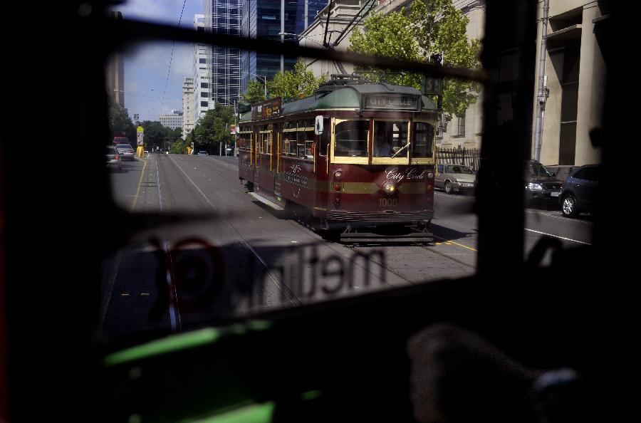 Two trams meet in Melbourne, Australia, Jan. 28, 2013. Melbourne's trams network is one of the largest functioning tram networks in the world. Among all the routes, No. 35, the City Circle Tram provides a free and convenient way for visitors to see the sights of central Melbourne while experiencing a ride on one of the city's much loved heritage trams. (Xinhua/Chen Xiaowei)