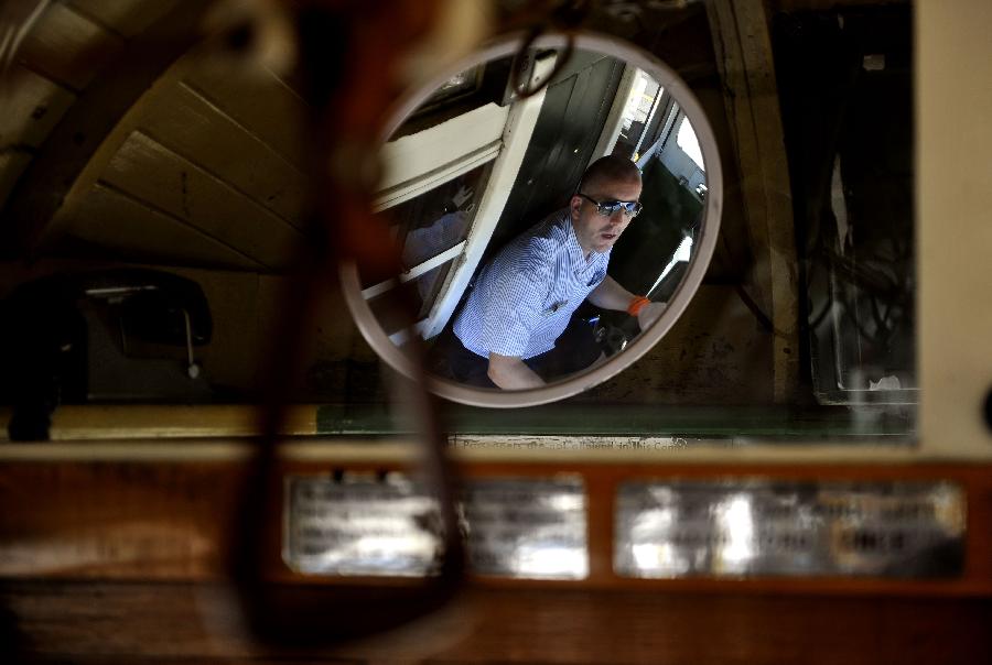 The driver of a tram looks in the rearview mirror in Melbourne, Australia, Jan. 28, 2013. Melbourne's trams network is one of the largest functioning tram networks in the world. Among all the routes, No. 35, the City Circle Tram provides a free and convenient way for visitors to see the sights of central Melbourne while experiencing a ride on one of the city's much loved heritage trams. (Xinhua/Chen Xiaowei)