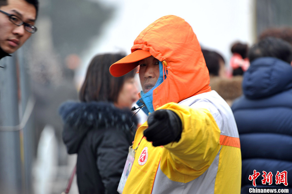 A photo taken on Jan. 29 shows a traffic warden working in the foggy weather. The fourth round of heavy smog in four weeks hit Beijing on Tuesday and led to serious air pollution, which has sent more people with respiratory illnesses to hospitals. However, a group of people had to stay on jobs outdoors. (Chinanews.com/Jin Shuo)