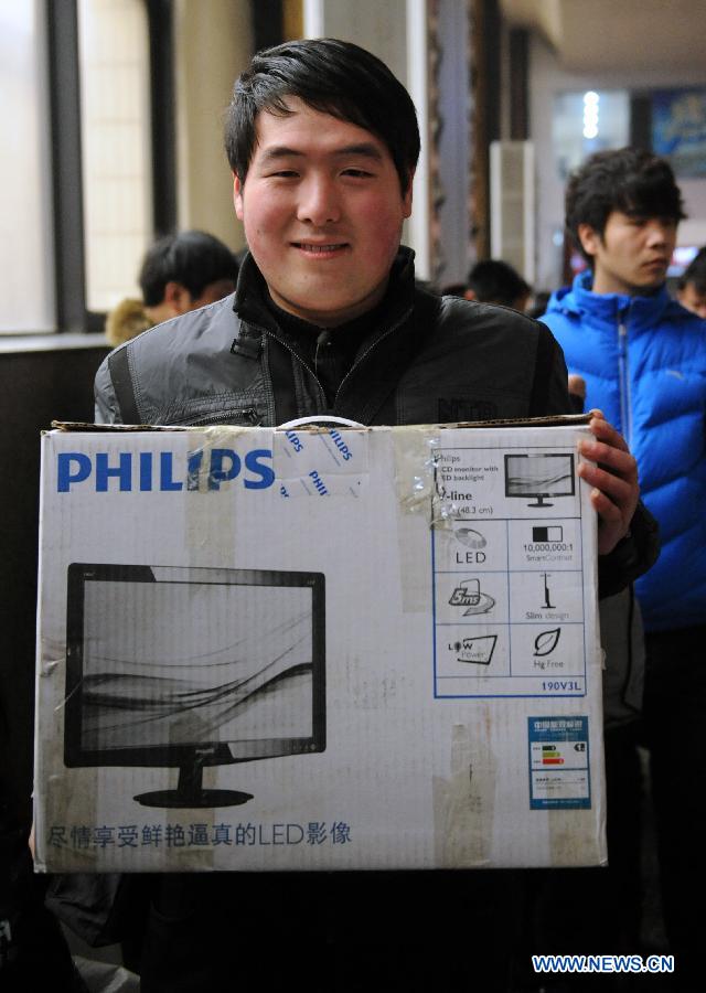 A passenger shows the gift for his family at the Zhengzhou Railway Station in Zhengzhou, capital of central China's Henan Province, Jan. 30, 2013. The 40-day Spring Festival travel rush started on Jan. 26. The Spring Festival, which falls on Feb. 10 this year, is traditionally the most important holiday of the Chinese people. It is a custom for families to reunite in the holiday, a factor that has led to massive seasonal travel rushes in recent years as more Chinese leave their hometowns to seek work elsewhere. Public transportation is expected to accommodate about 3.41 billion travelers nationwide during the holiday, including 225 million railway passengers.(Xinhua/Li Bo) 