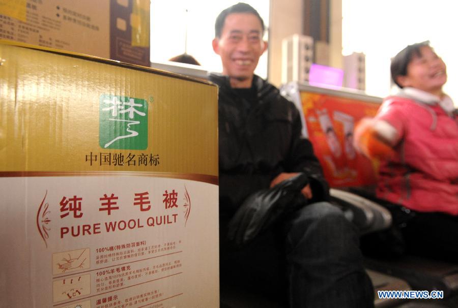 A passenger shows the gift for his family at the Zhengzhou Railway Station in Zhengzhou, capital of central China's Henan Province, Jan. 30, 2013. The 40-day Spring Festival travel rush started on Jan. 26. The Spring Festival, which falls on Feb. 10 this year, is traditionally the most important holiday of the Chinese people. It is a custom for families to reunite in the holiday, a factor that has led to massive seasonal travel rushes in recent years as more Chinese leave their hometowns to seek work elsewhere. Public transportation is expected to accommodate about 3.41 billion travelers nationwide during the holiday, including 225 million railway passengers.(Xinhua/Li Bo)