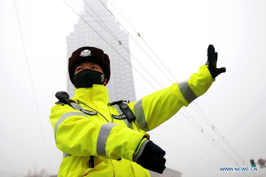 A traffic policewoman with a mask directs the traffic in Jinan, capital of east China's Shandong Province, Jan. 30, 2013. The local traffic policemen used masks to protect their health in hazy days.(Xinhua/Xu Suhui) 