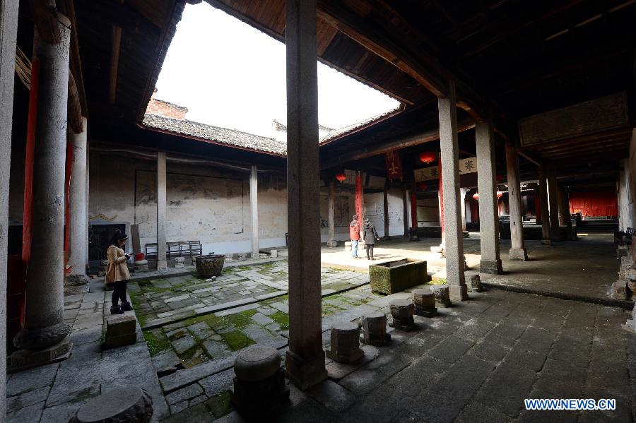 Tourists visit an ancient building in Tianbao Village in Yifeng County, east China's Jiangxi Province, Jan. 30, 2013. Tianbao Village, whose history is about 1,800 years, can date back to the Tang Dynasty (618-907), covering an area of more than 2.5 square kilometers. Tianbao was ever the county site of the ancient Yifeng County, carrying profound cultural connotation. There are more than 120 buildings in the village built in the Ming and Qing dynasties (1368-1912), all of which present high artistic value. The village has been listed in the pool of national cultural and natural heritage protection projects. (Xinhua/Song Zhenping)